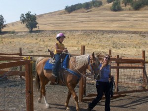 Picture of a boy being led on a horse by a session leader.
